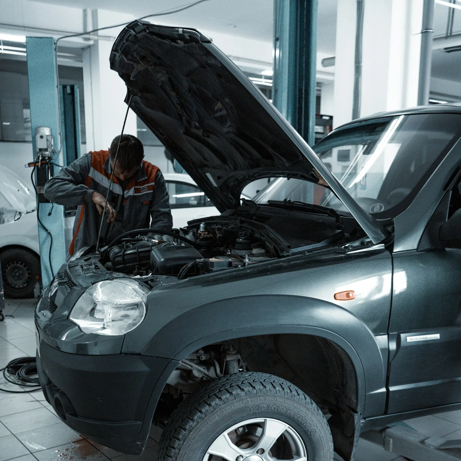 Mechanic working on a vehicle with the hood open
